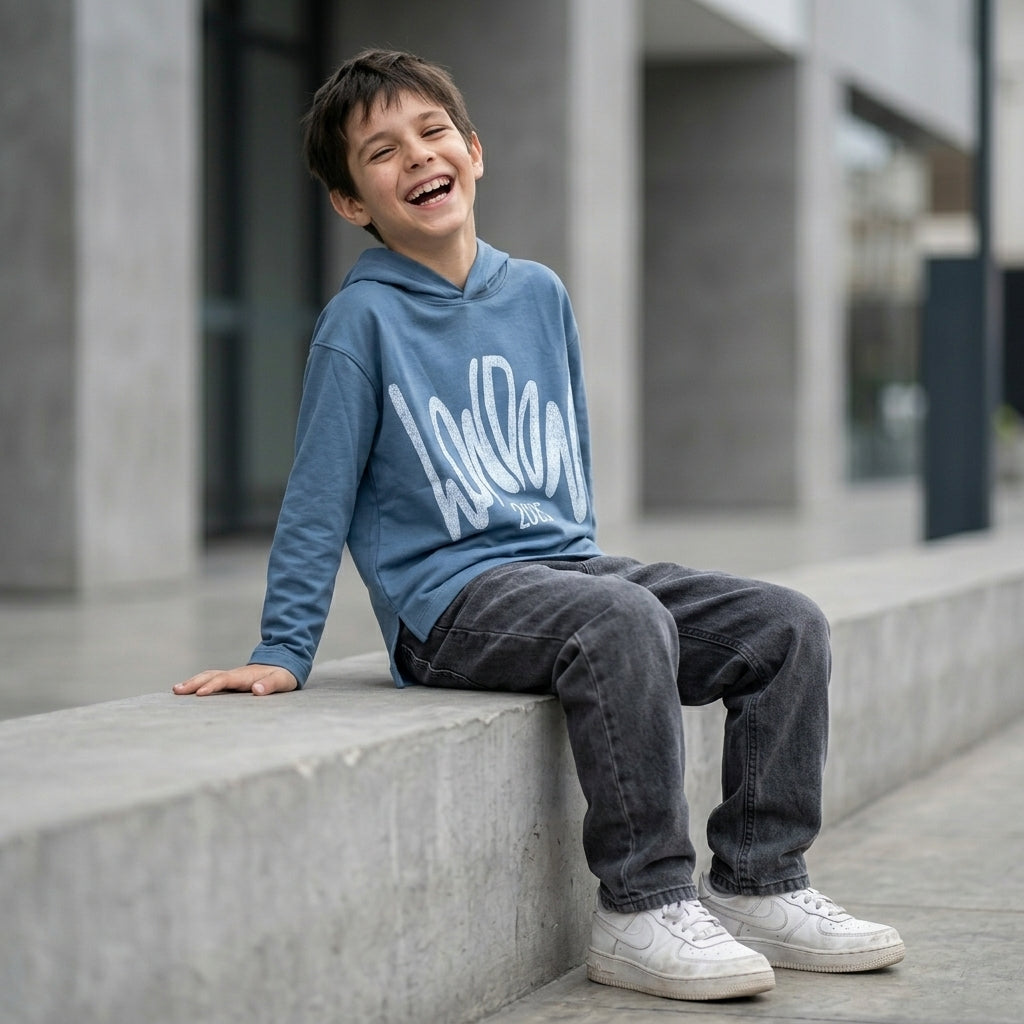 Niño con hoodie London 2025 azul ANG Kidz – look streetwear con jean negro